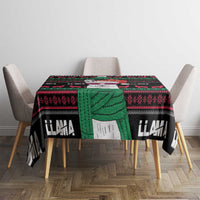 Llama patterned tablecloth with draped center and fringed edge; black, green, and red