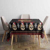 Black tablecloth with sloth faces pattern and red plaid stripe over dining table