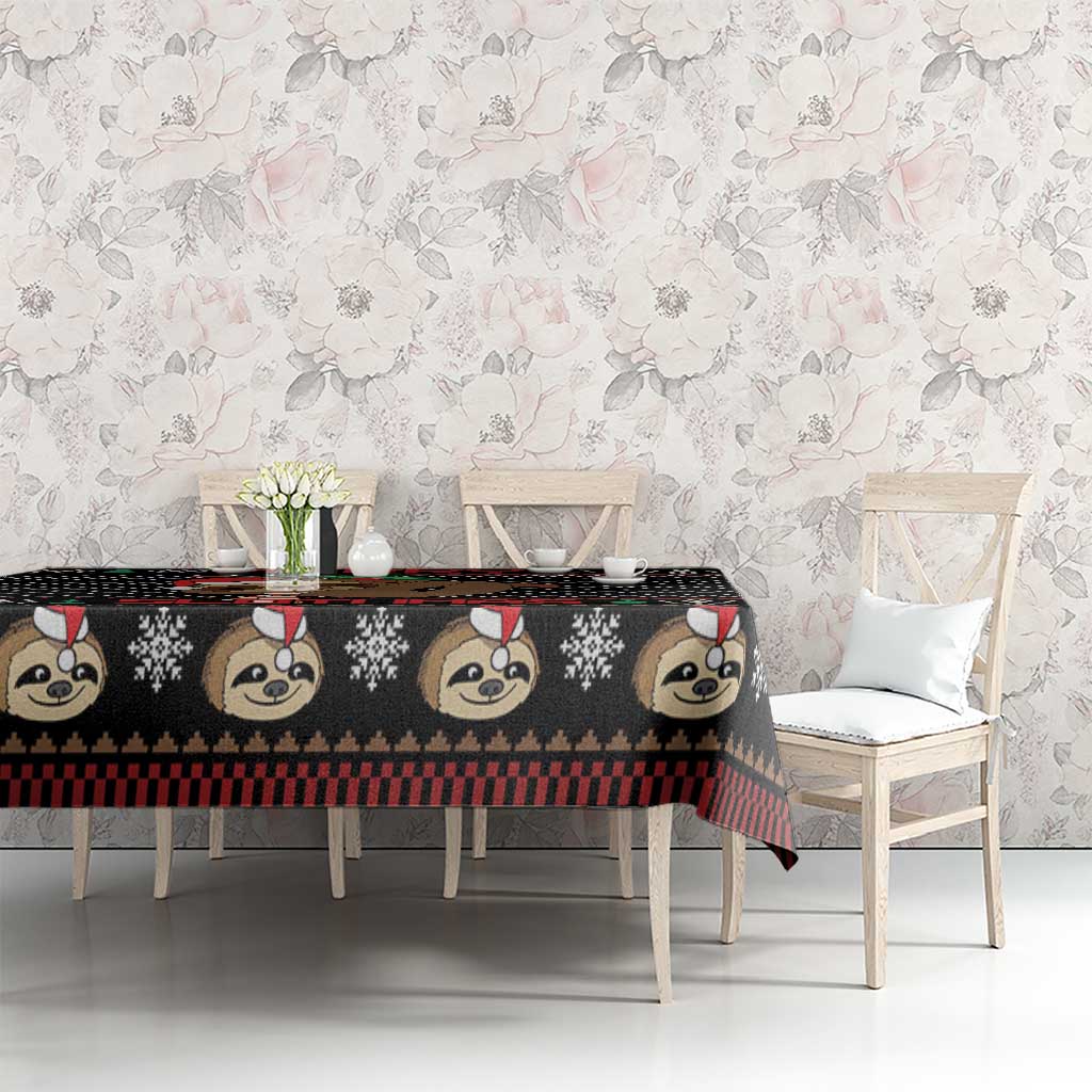 Black sloth Christmas tablecloth with repeating animal faces and festive check stripe