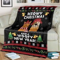 Black holiday blanket on couch with cat and dog faces, snowy icons and red border