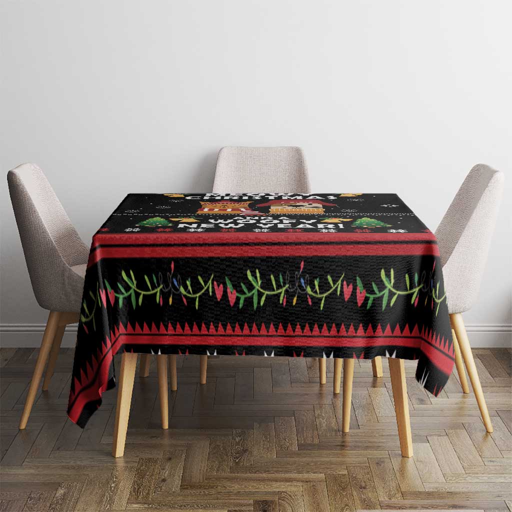 Black holiday tablecloth with cat and dog scenes, red stripe and green grass pattern