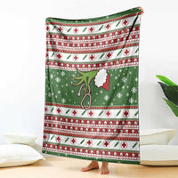 Green Christmas blanket hanging down, red striped pattern with white crosses and clinic symbols.