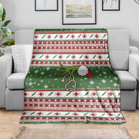 Green Christmas blanket draped on couch, red and white cross stripes with stethoscope graphic.