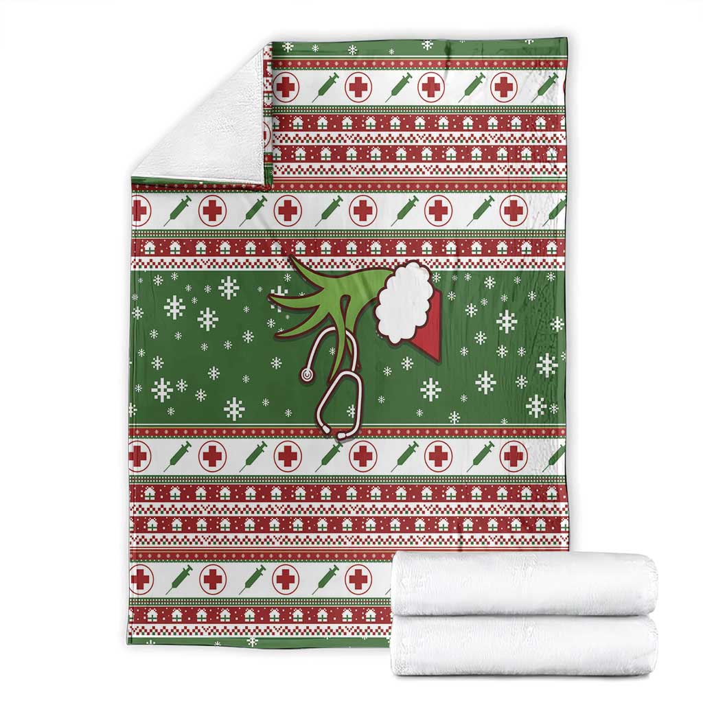 Folded green Christmas blanket set, red-and-white cross stripes with stethoscope and snowflakes.