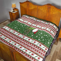 Green holiday quilt on bed with red-and-white stripe border, snowflakes, and holly sprig
