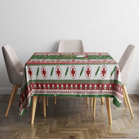 Green Christmas tablecloth on rectangular table, red medical-cross holiday design