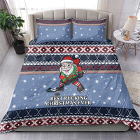 Blue comforter and pillow shams set with hockey Santa elf and striped Nordic Christmas design.
