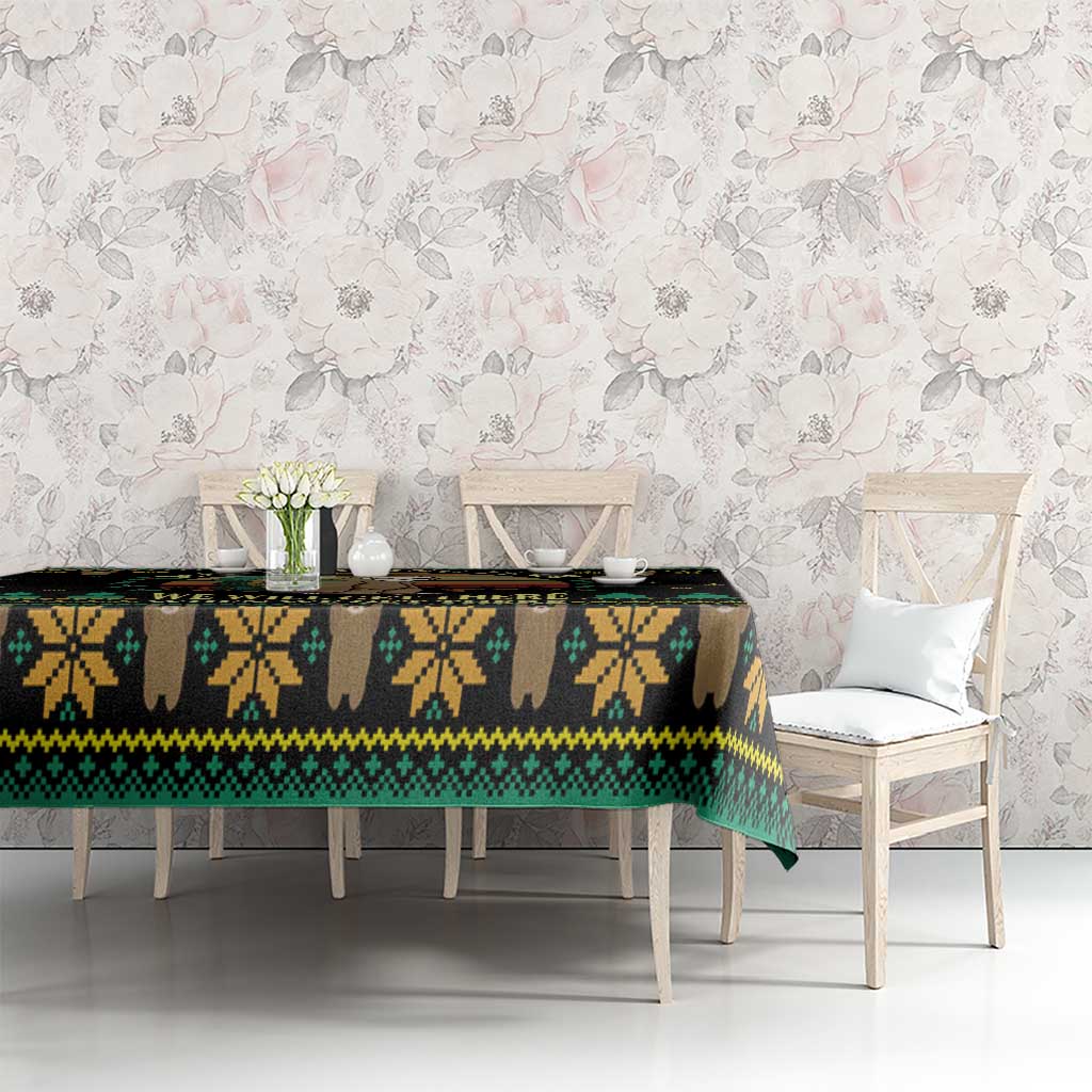 Black sloth-themed tablecloth with green and yellow pattern across dining table