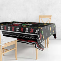 Black Christmas tablecloth draped over bench with red, white, and green motif strips