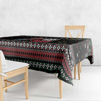 Black festive tablecloth with red, white, and green zigzag pattern and snowflake trim