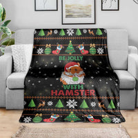 Black hamster holiday blanket draped on gray sofa with trees and snowflake pattern