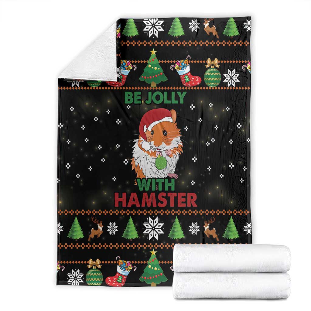 Black holiday blanket folded with central gnome hamster print, 'Be Jolly' and snowflakes