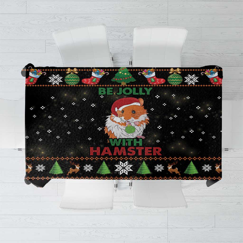 Black holiday tablecloth with colorful trees, socks, and hamster “Be Jolly” text