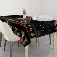 Black holiday tablecloth with colorful Christmas icons and overhanging corner drape