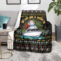 Black Christmas blanket draped on chair, showing Santa, boat, and festive border