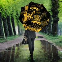 Black umbrella with yellow military graphic, person holding it in rain