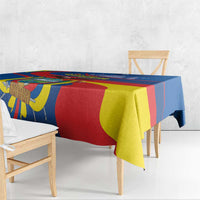 Blue rectangular tablecloth with Ecuador-inspired multicolor pattern draping over table edge