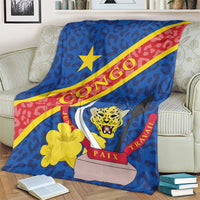 Blue throw blanket showing leopard head, yellow star, and red diagonal stripe with seal