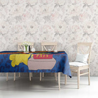 Blue tablecloth on dining table with leopard-style pattern and “PAIX” patch