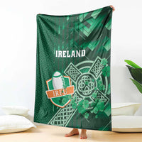 Green Ireland rugby blanket held upright with Ireland lettering, Celtic cross and shamrock print