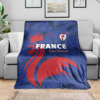 Blue France rugby blanket with red lion graphic and Les Bleus text, on gray sofa