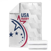 Folded white USA Rugby throw blanket with USA Rugby emblem and rolled stacks