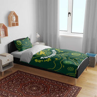 Green duvet cover on a bed with yellow Australia crest and wavy dot pattern