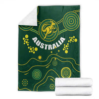 Green Australia rugby blanket with Wallabies kangaroo emblem, stacked with white towels