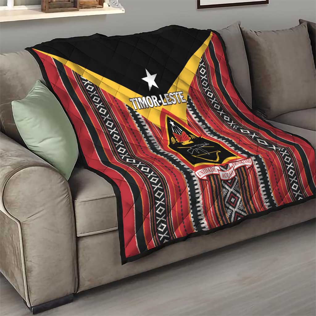 Red and black quilt draped on sofa with white star, yellow chevrons, and stripe bands