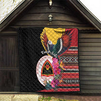 Black quilt hanging on wall with bird, red-yellow wings, crest, and geometric stripe trim