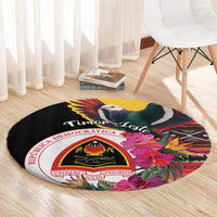 Black round carpet close view with bird, “Timor-Leste” script, hibiscus floral crest