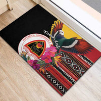 Black rubber doormat corner view with pigeon, hibiscus flowers, Timor crest and patterned stripe