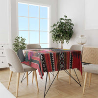Black tablecloth over dining table with multicolor patterned stripes and hibiscus flowers