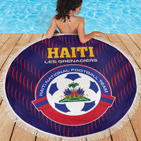 Round blue beach blanket with red vertical stripes, Haiti crest, and white fringed border.