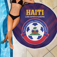 Round blue beach blanket with red stripes and team crest, with white fringed edge.