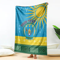 Blue Rwanda-style throw blanket featuring central crest and sunburst graphic with trim bands