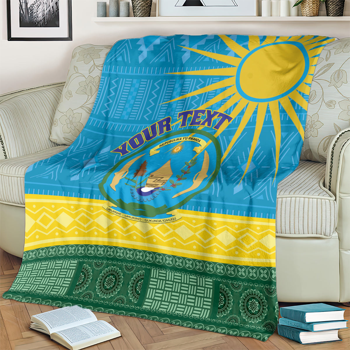 Blue patterned Rwanda-themed blanket with sunburst, crest logo, and bold yellow and green bands