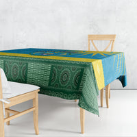 Green patterned personalized tablecloth with blue and yellow geometric border, draped on table