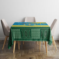 Personalized tablecloth with green patterned design and blue emblem border over table