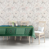 Personalized tablecloth with green patterned center and blue-yellow border on table