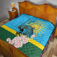 Blue quilt on bed with leopard center graphic, sunrays, pink roses, green-yellow stripes.