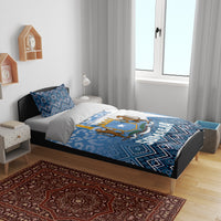Blue and white bedding set on bed with Somalia shield emblem and geometric blue pattern