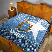 Blue and white Somalia quilt on bed with shield star and quilted diamond pattern