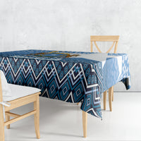 Blue geometric patterned tablecloth with diamond and stripe motifs draped over table