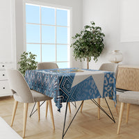 Blue patterned tablecloth with geometric motifs on dining table with visible chairs