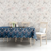 Blue geometric tablecloth on dining table with chair backs visible