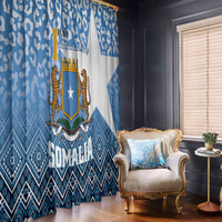 Blue and white window curtain with Somali crest and leopard pattern, hanging over a window
