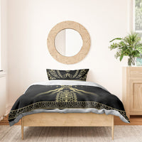 Black duvet and pillowcases with gold central crest, flowing lines, and decorative edge trim