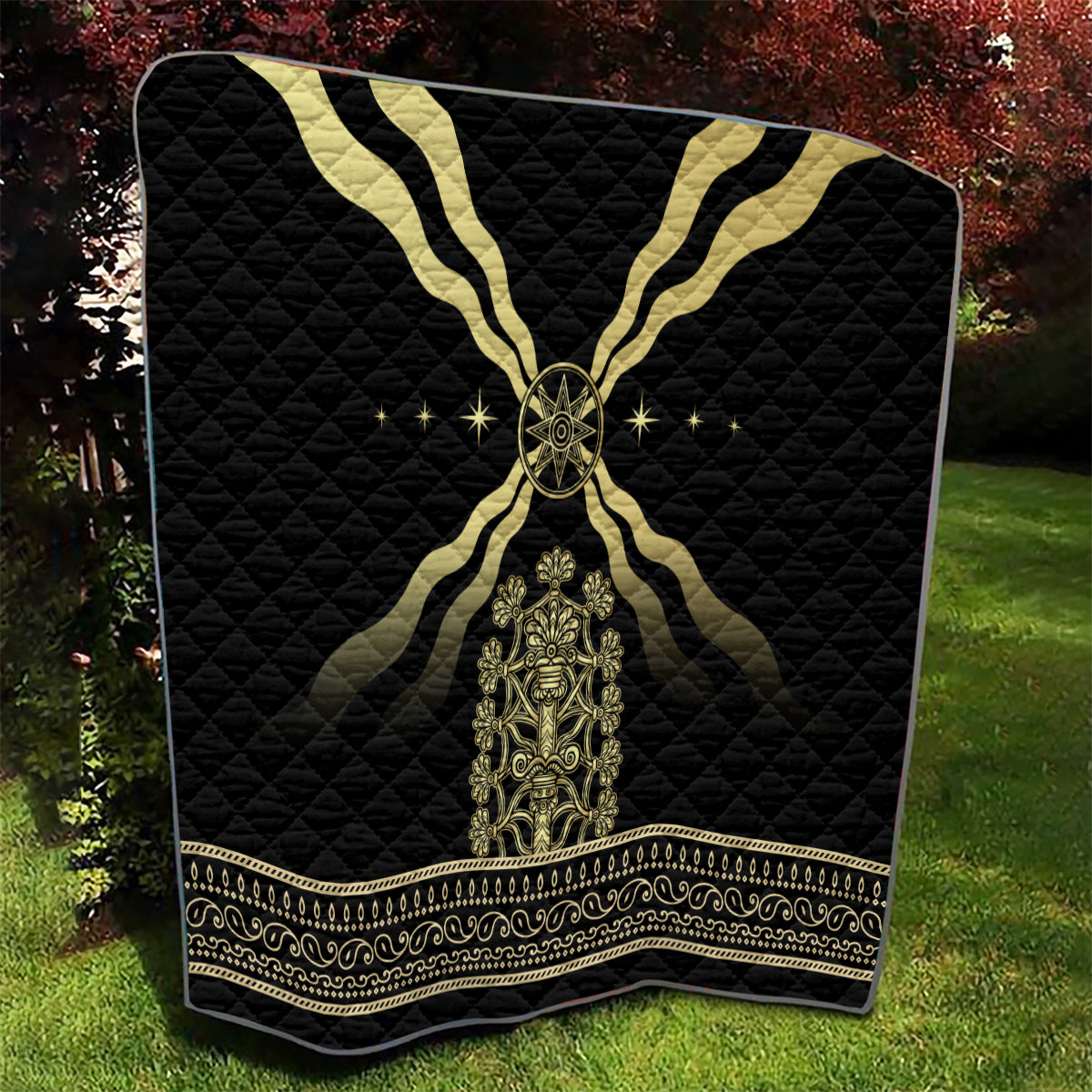 Black quilt blanket with gold emblem at center, gold cross motif, and patterned edge