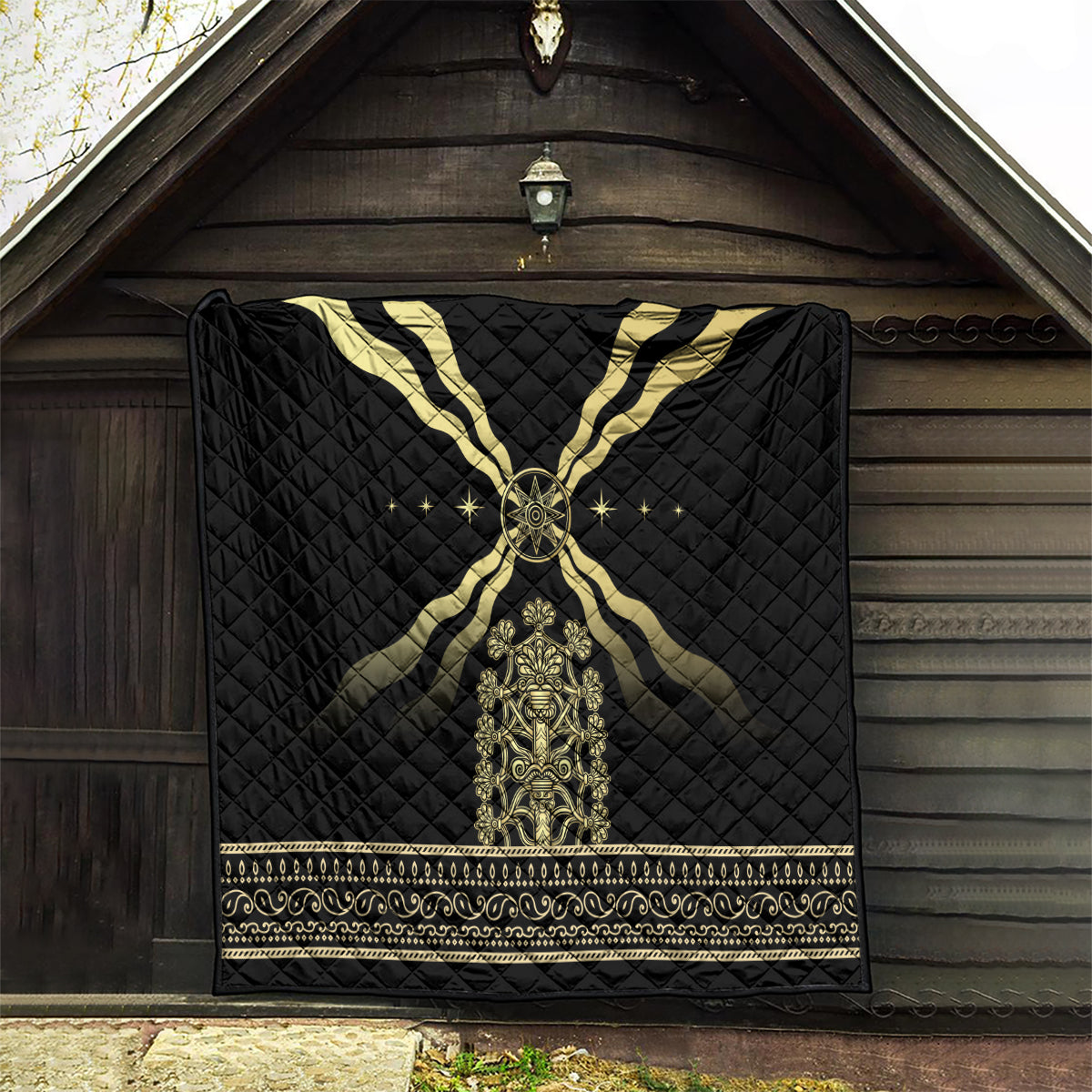 Black quilt blanket showing gold cross rays, central emblem, and ornate banded border